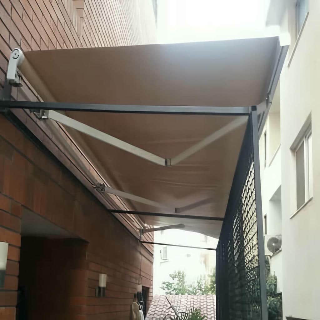 سایبان تاشو در حالت جمع شده کنار دیوار